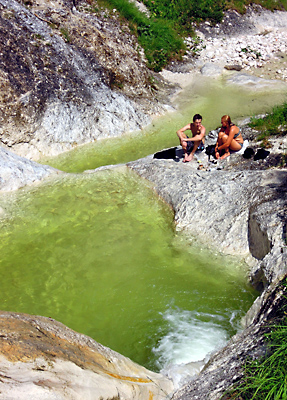Sandsteingumpen mit eiskaltem grün schimmerndem Quellwasser in der Aschauer Klamm