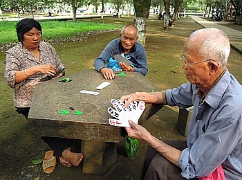 Oma und Opa im Park beim Kartenspiel