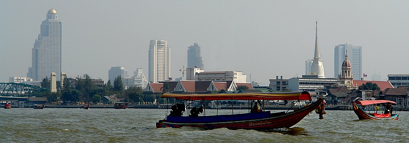 Bootsfahrt auf den Klongs von Thonburi, im Hintergrund die Skyline von Bangkok
